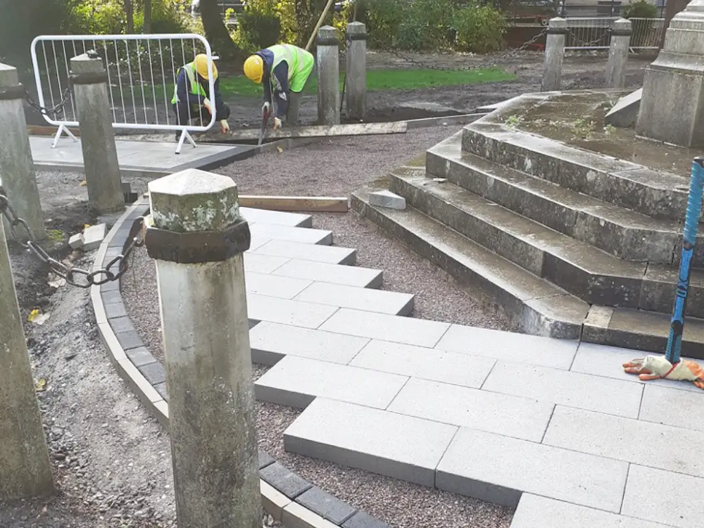 A photo of block paving being installed around the memorial.